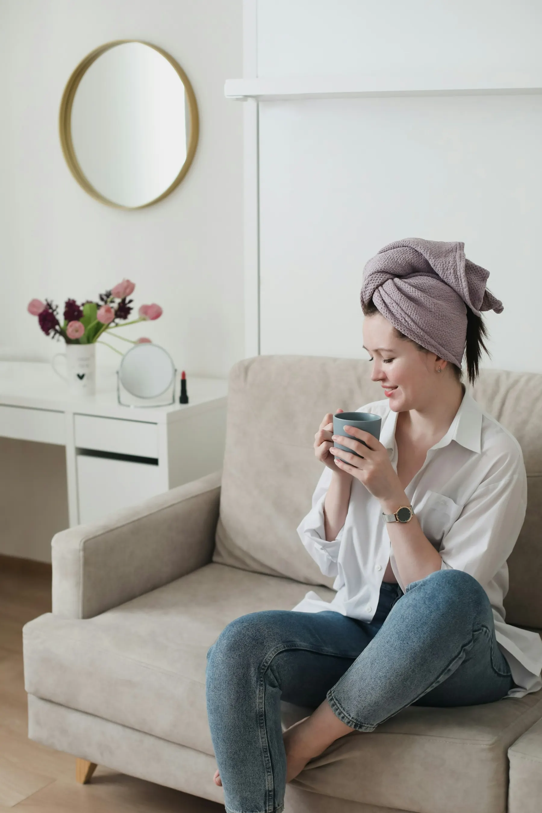 A young woman wearing a headscarf, relaxing at home with a warm drink